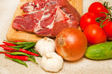 Fototapeta Kuchnia - Fresh lamb meat and vegetables on a kitchen counter