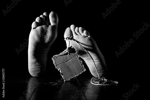 Fotografie, Tablou Death. Feet of a corpse on a wooden floor with cardboard