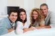 © goodluz - Group of friends sitting in sofa watching tv