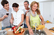© goodluz - Group of friends prepraing dinner in home kitchen