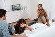 © goodluz - Group of friends sitting in sofa watching tv