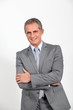 © goodluz - Smiling businessman standing on white background