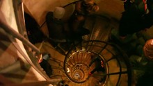 People Ascending Narrow Spiral Staircase In Old Building