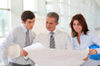 © goodluz - Architects meeting in hall with construction plan