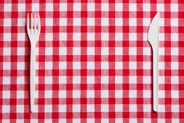 Wall Mural - plastic cutlery on checkered tablecloth