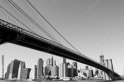 manhattan-bridge-z-widokiem-na-drapacze-chmur-i-wiezowce-w-tle-czarno-biala-fotografia-nowego-jorku