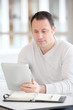© goodluz - Office worker in the office using electronic tab