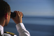 Offizier schaut mit dem Fernglas übers Meer