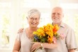 © nyul - Portrait of happy elderly couple with flowers