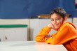 © Darrin Henry - Schoolboy 10 wearing orange hoodie resting on classroom desk