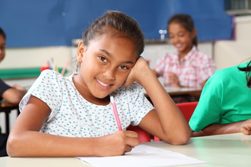 Wall Mural - Happy school girl with beautiful smile in class