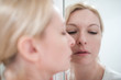 © Sergey Skleznev - Beautiful blonde young woman looking in a mirror, close-up refle