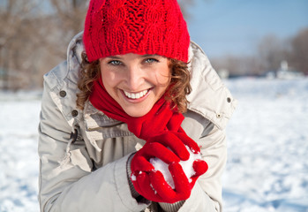 Happy young woman playing snowball fight on the snow day