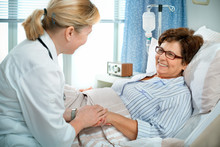 Doctor Or Nurse Talking To Patient In Hospital