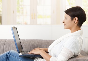 Wall Mural - Young woman using laptop