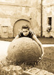 Young woman try to raise big stone ball