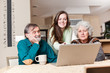 Teenage girl with grandparents using laptop
