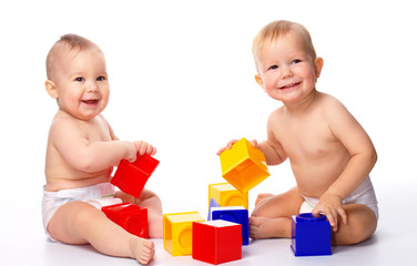 Two children play with building bricks