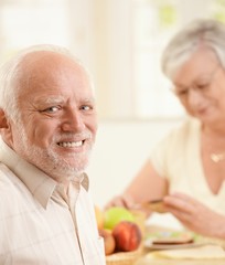 Poster - Portrait of happy senior man at breakfast