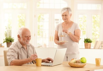 Sticker - Senior man with computer and coffee in kitchen