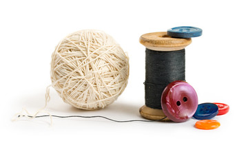 Thread bobbin, ball and buttons isolated on white background