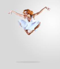 Woman dancer jump posing on background