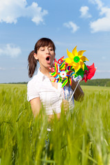 Poster - frau auf der wiese mit windrad