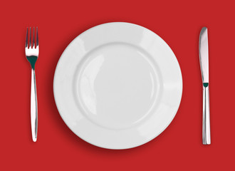 knife, white plate and fork on red background