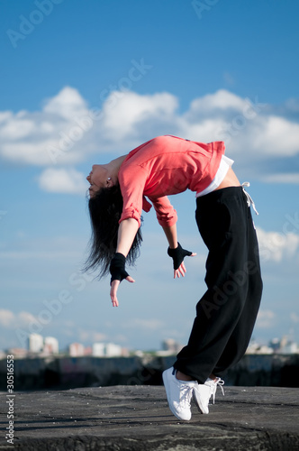 Fototapeta na wymiar woman dancing hip hop over blue sky