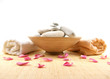 A spa composition of stones, pink petals and two towels