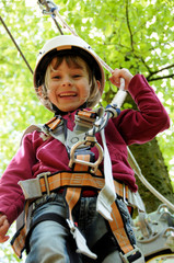 Mädchen mit Helm beim Klettern im Wald