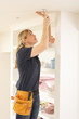 © Monkey Business - Female Electrician Installing Light Fitting In Home