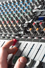 Wall Mural - Closeup of an audio sound mixer with the hand of a man