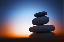 Zen Stones At Night Over Sunrise Background