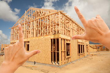 Wall Mural - Female Hands Framing Home Frame on Construction Site