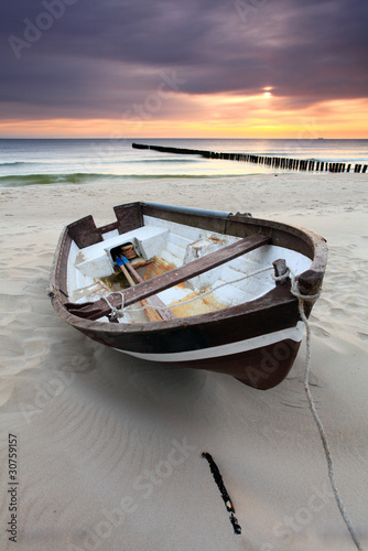 Nowoczesny obraz na płótnie Boat on beautiful beach in sunrise