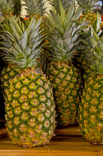 A Group Of Pineapples On A Wooden Shelf