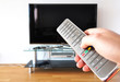 © pincasso - Remote control in the hand against TV screen