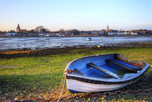 Old Rowing Boat In Low Tide Harbour Landscape At Sunset