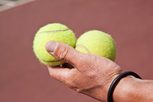 Tennisplayer Holding Two Balls In His Hand On Court