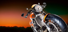 Motorcycle Under An Orange Sky And Mountains Background.