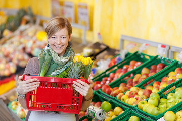 glückliche junge frau beim einkauf im supermarkt