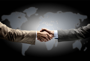 Handshake with map of the world in background