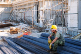 Fototapeta Krajobraz - Construction worker resting on steel bars