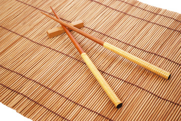 Wall Mural - Chopsticks on brown bamboo matting background