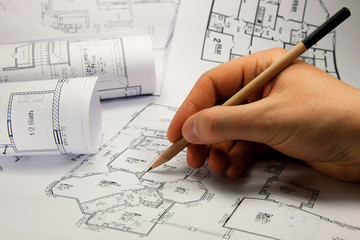 architect's hand with pencil drawing plan