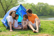 © Pavel Losevsky - Happy family with two children sitting in tent
