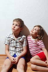 Wall Mural - Little girl and thoughtful boy in home clothes sitting