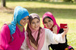 three muslim girls with cellphone