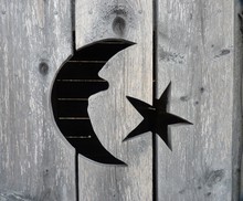 A Closeup Of The Moon And Star Cutout On An Old Outhouse